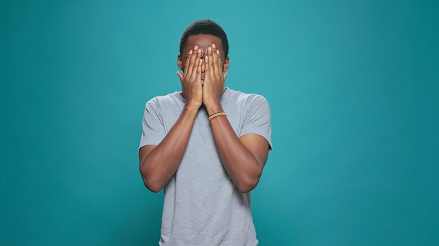 Young adult doing three wise monkeys gesture on camera, covering eyes, mouth and ears as wisdom sayings. Modern person advertising silence concept with hand, casual formal reaction over background.