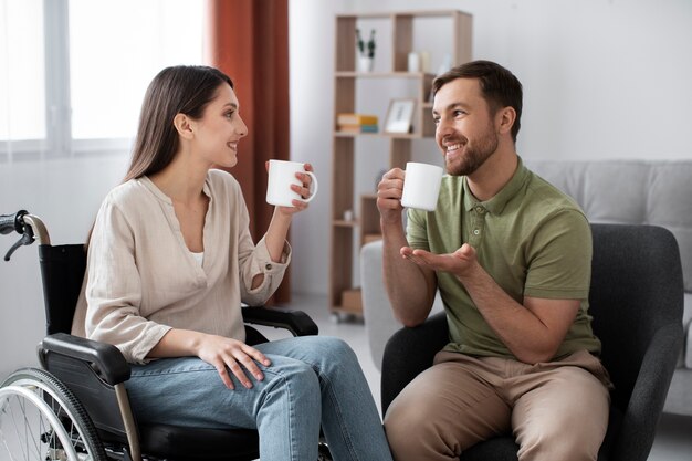 Young adult having coffee with disabled friend