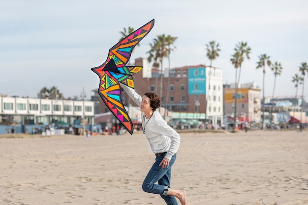 Free photo young adult having fun with kite