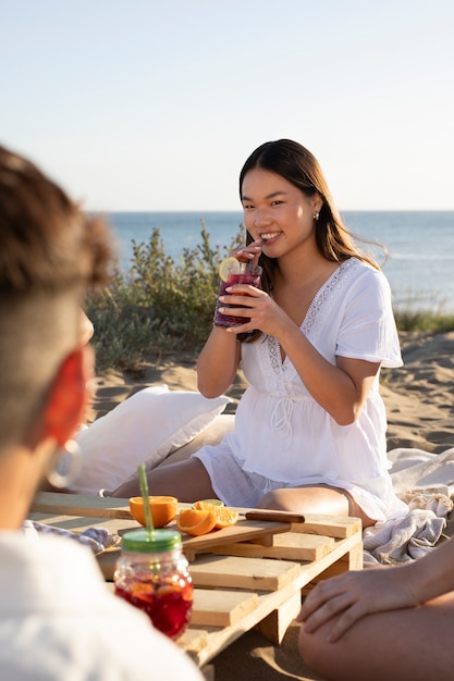 Free photo young adult having a sangria party by the beach