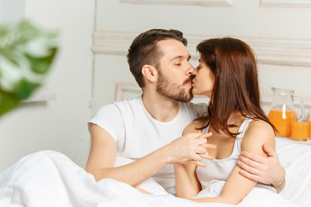 Young adult heterosexual couple lying on bed in bedroom