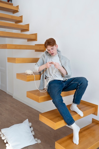 Young adult knitting at home