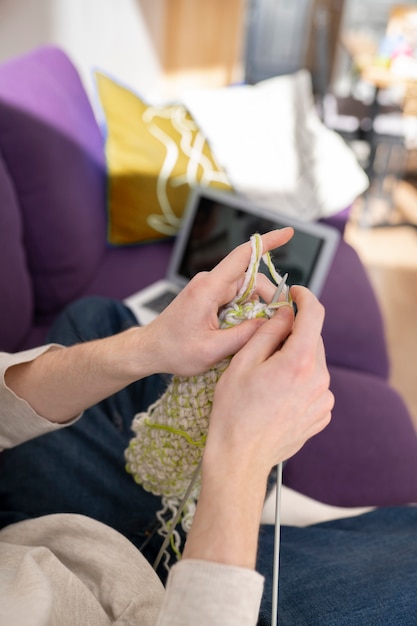 Free photo young adult knitting at home