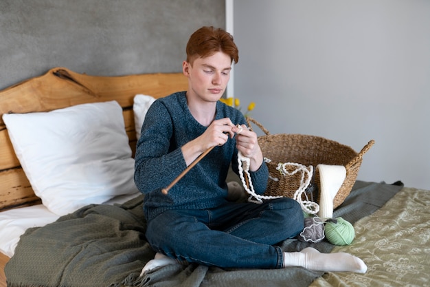 Young adult knitting at home