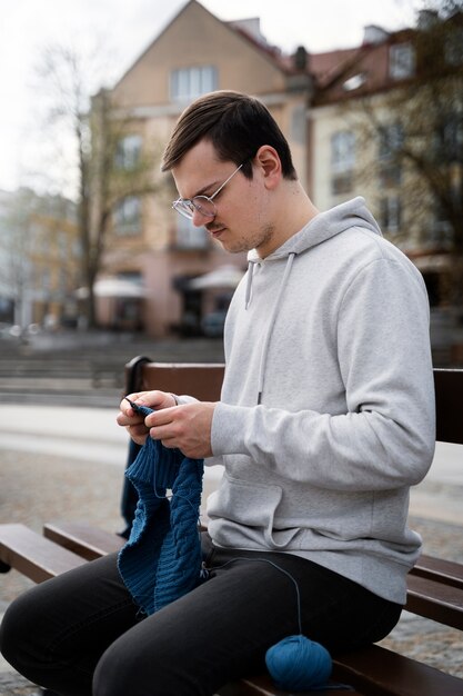 Young adult knitting outside