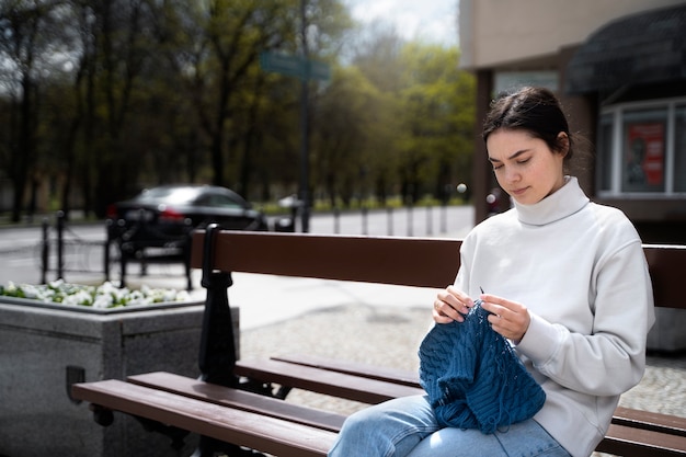 Free Photo young adult knitting outside