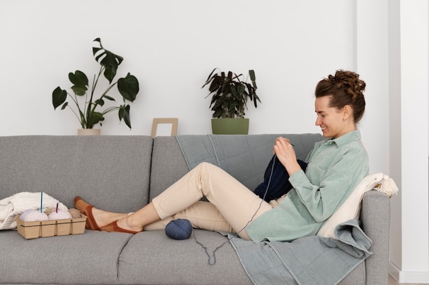 Free photo young adult relaxing while knitting