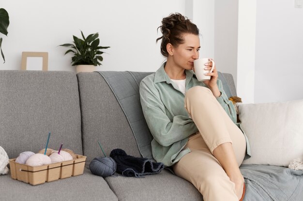 Young adult relaxing while knitting