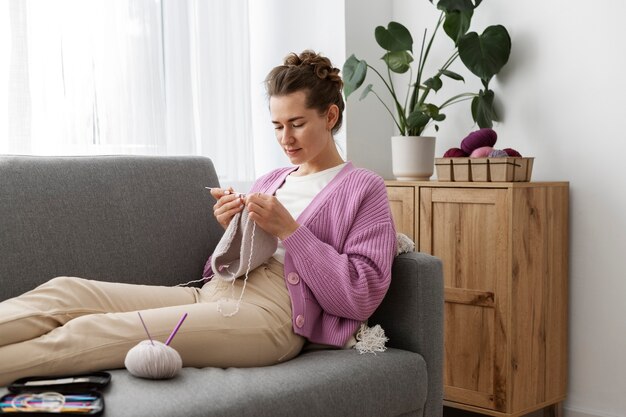 Young adult relaxing while knitting