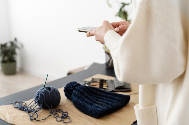 Young adult taking picture of their knitting product