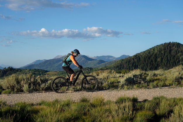 Free photo young adult using electric bike in the country side