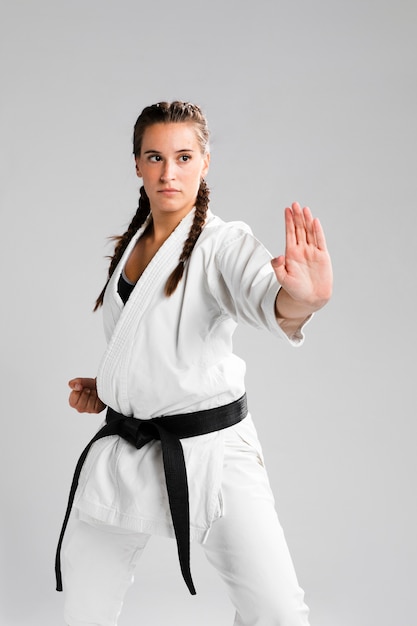 Young adult woman with black belt fighter training karate