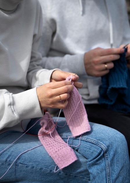 Free photo young adults knitting outside