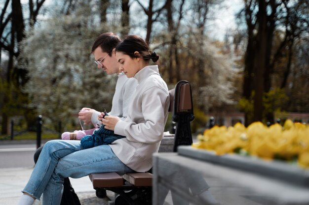 Young adults knitting outside