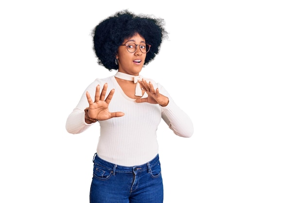 Young african american girl wearing casual clothes and glasses afraid and terrified with fear expression stop gesture with hands, shouting in shock. panic concept.