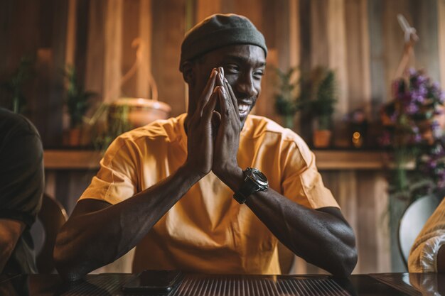 Young African American male smiling at dinner with his friends