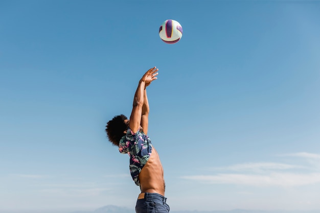 Free Photo young african american man jumping and throwing ball