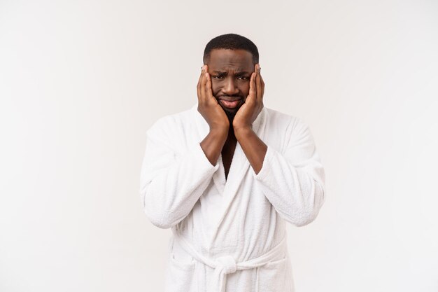 Young african american man wearing bathrobe over isolated white background thinking looking tired and bored with depression problems