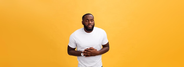 Young african american man wearing white tshirt with hand on stomach because nausea painful disease