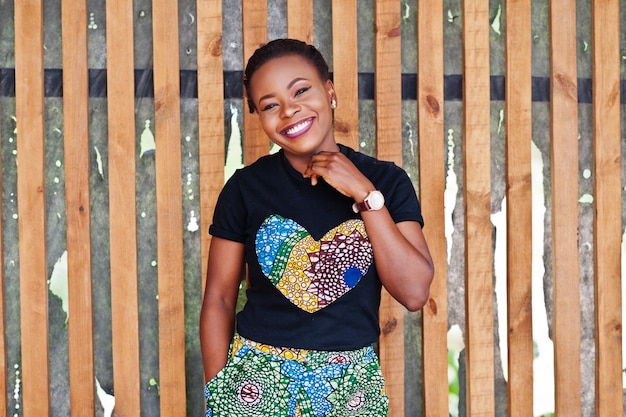 Free photo young african american woman posed against wooden wall