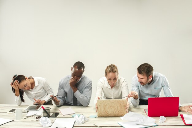 Young african and caucasian men and women sitting at office and working on laptops.