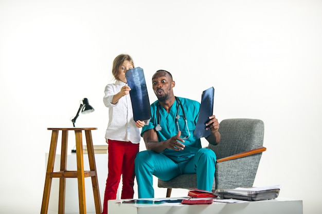 Young african male pediatrician explaining X-ray to child