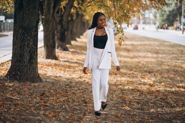 Young african woman dressed in white suit in park