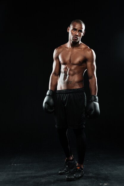 Young afroamerican boxer in gloves, standing