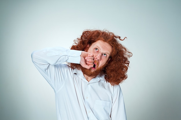 Free Photo the young angry man with long red hair beating himself