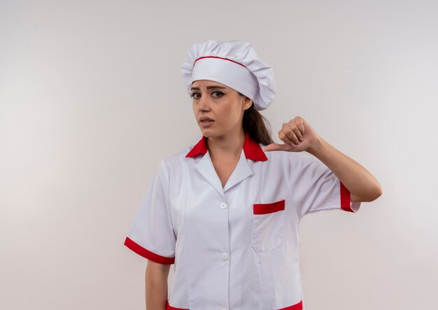 Young annoyed caucasian cook girl in chef uniform thumbs down isolated on white background with copy space