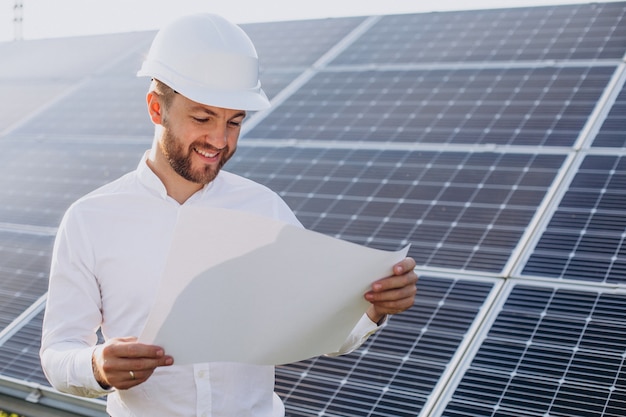 Young architect standing by solar panels