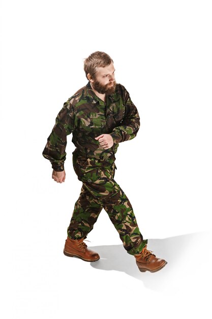 Young army soldier wearing camouflage uniform going isolated on white studio