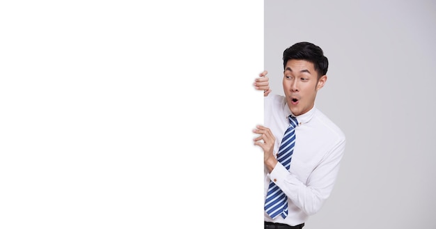 young Asian business man showing blank signboard isolated on white background