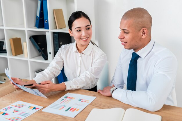 Young asian businesswoman showing business report to her colleague