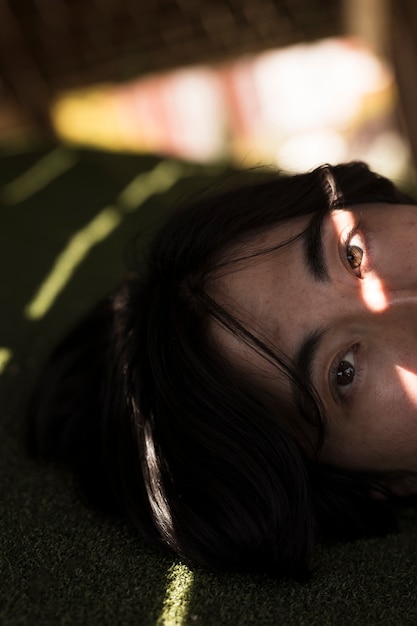 Free photo young asian male looking at camera in shadow