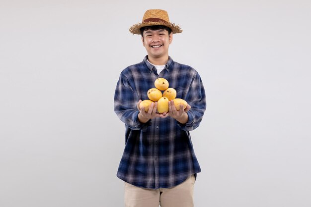 Young Asian smart farmer shows organic yellow mango fruit on white background