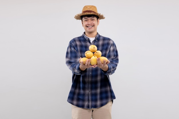 Young Asian smart farmer shows organic yellow mango fruit on white background