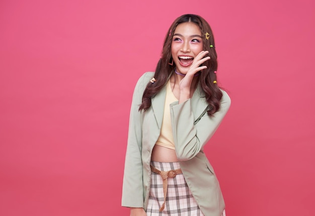 Young Asian teenage girl surprised excited isolated on pink background