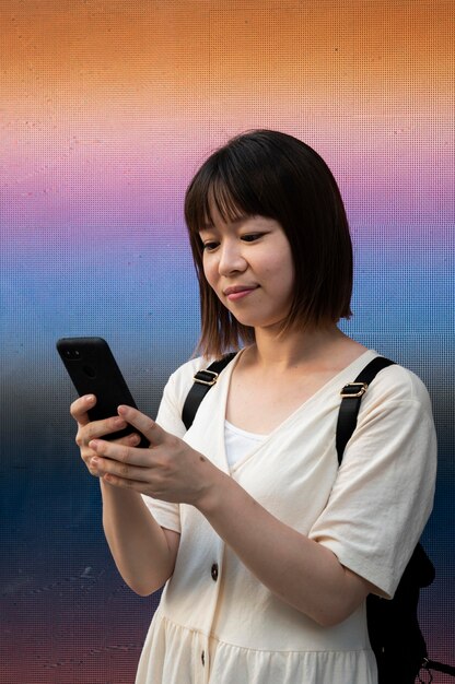 Young asian woman checking her phone outdoors