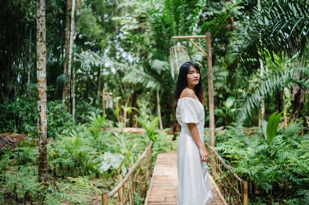 Young Asian woman relax in forest, Beautiful female happy using relax time in nature.