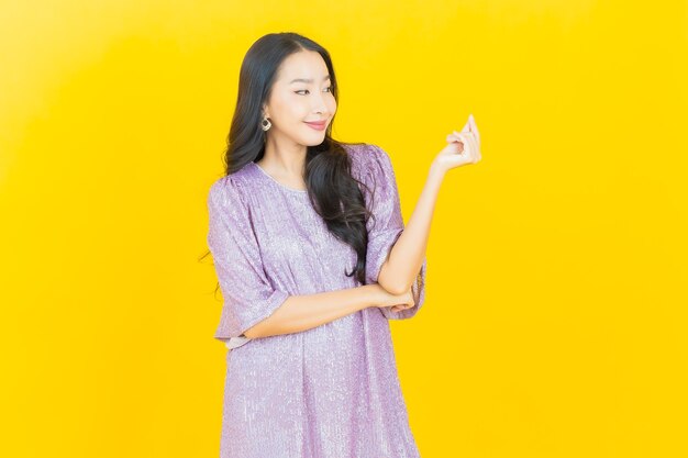 young asian woman smiling on yellow