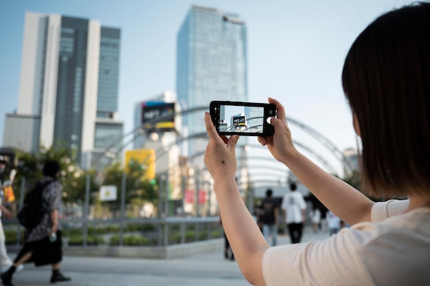 Free photo young asian woman taking a photo with her phone