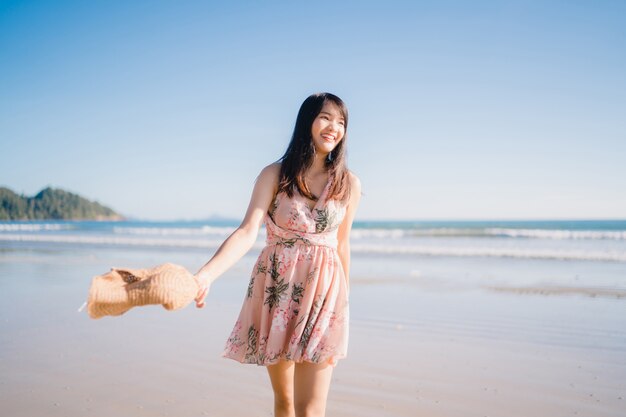 Young Asian woman walking on beach. Beautiful female happy relax walking on beach 