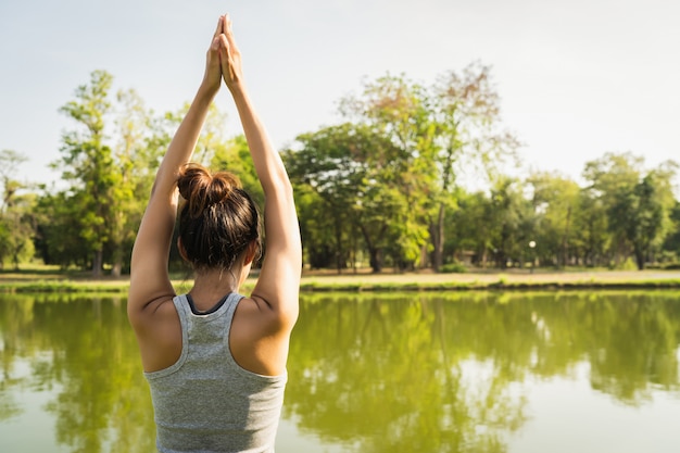 Free photo young asian woman yoga outdoors keep calm and meditates while practicing yoga