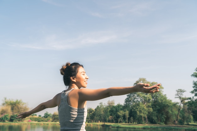 Young asian woman yoga outdoors keep calm and meditates while practicing yoga