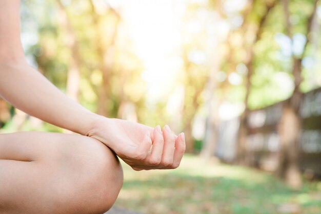 Young asian woman yoga outdoors keep calm and meditates while practicing yoga 