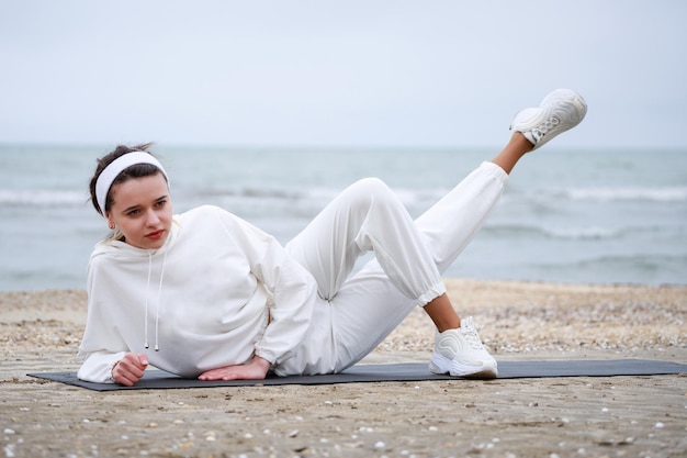 Young athlete laying on the yoga mat and stretching her body High quality photo