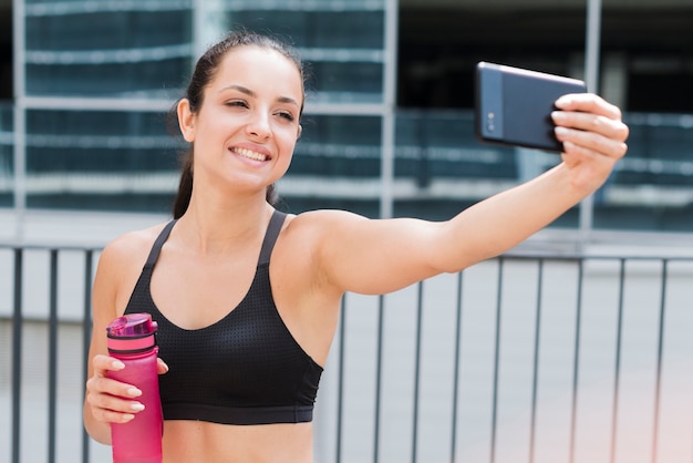 Free photo young athlete woman with a smartphone