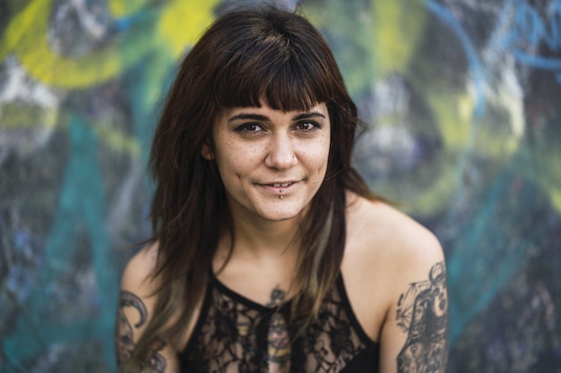 Young attractive Caucasian female with tattoos sitting on a skating ramp