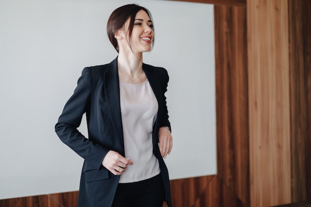 Free photo young attractive emotional girl in business-style clothes on a plain white background in an office or audience